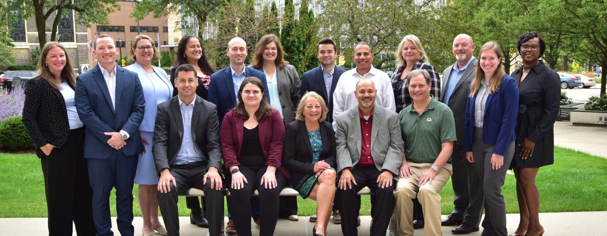 A group of professionals posing outdoors for a team photo.